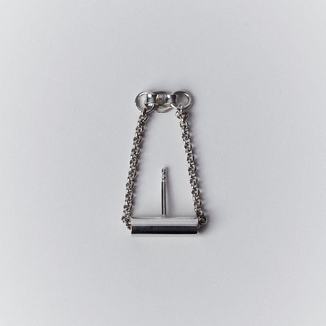 A silver earring with a chain running through a tube.