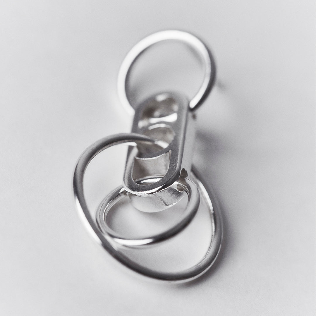 A silver earring with interconnected hanging rings.
