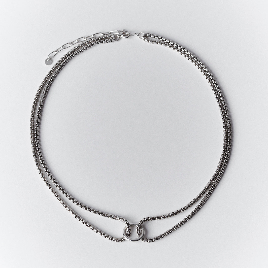 Thick silver choker necklace with a double venetian chain and a central ring.
