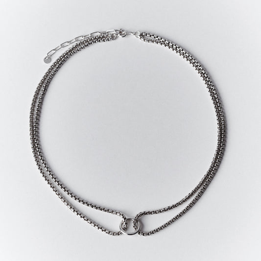 Thick silver choker necklace with a double venetian chain and a central ring.