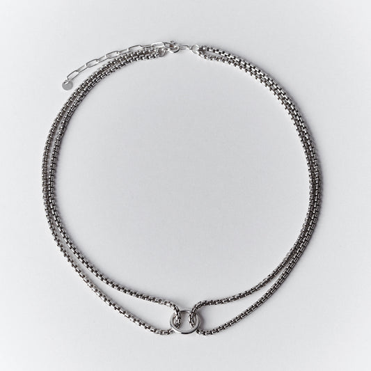 Thick silver choker necklace with a double venetian chain and a central ring. 