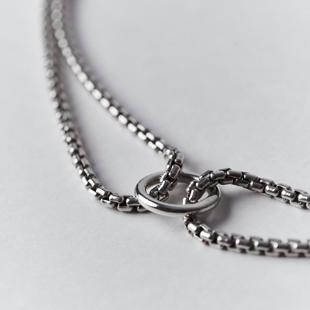 Detail of the ring of a silver choker necklace with a thick venetian chain.