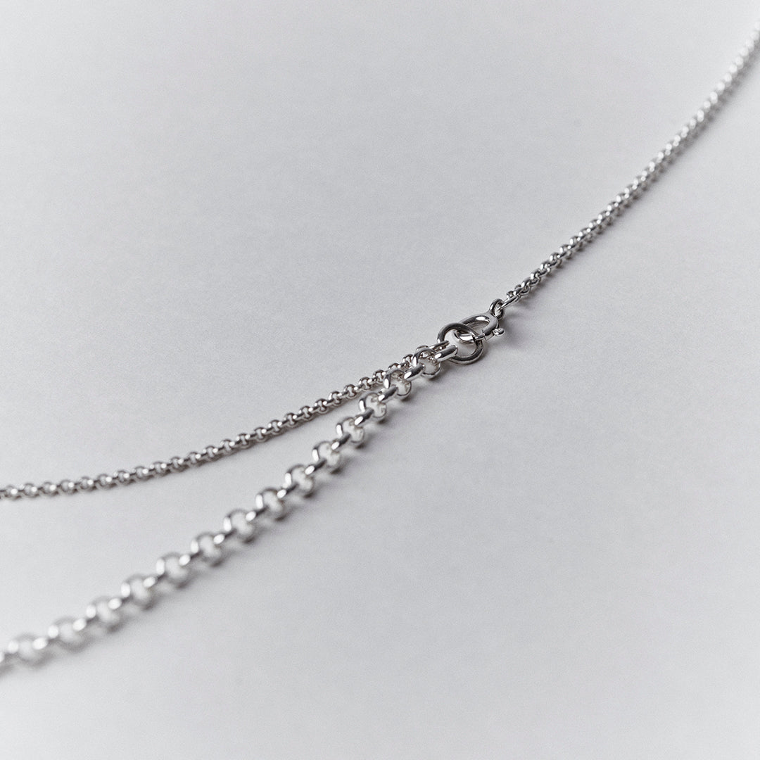 A detail of the clasp on an adjustable silver necklace.