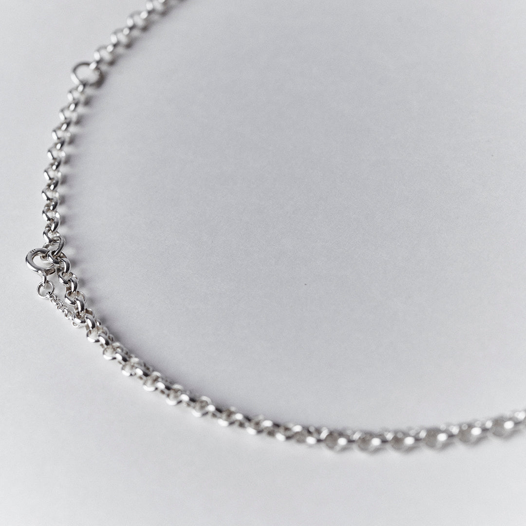 A detail of the clasp on an adjustable silver necklace.