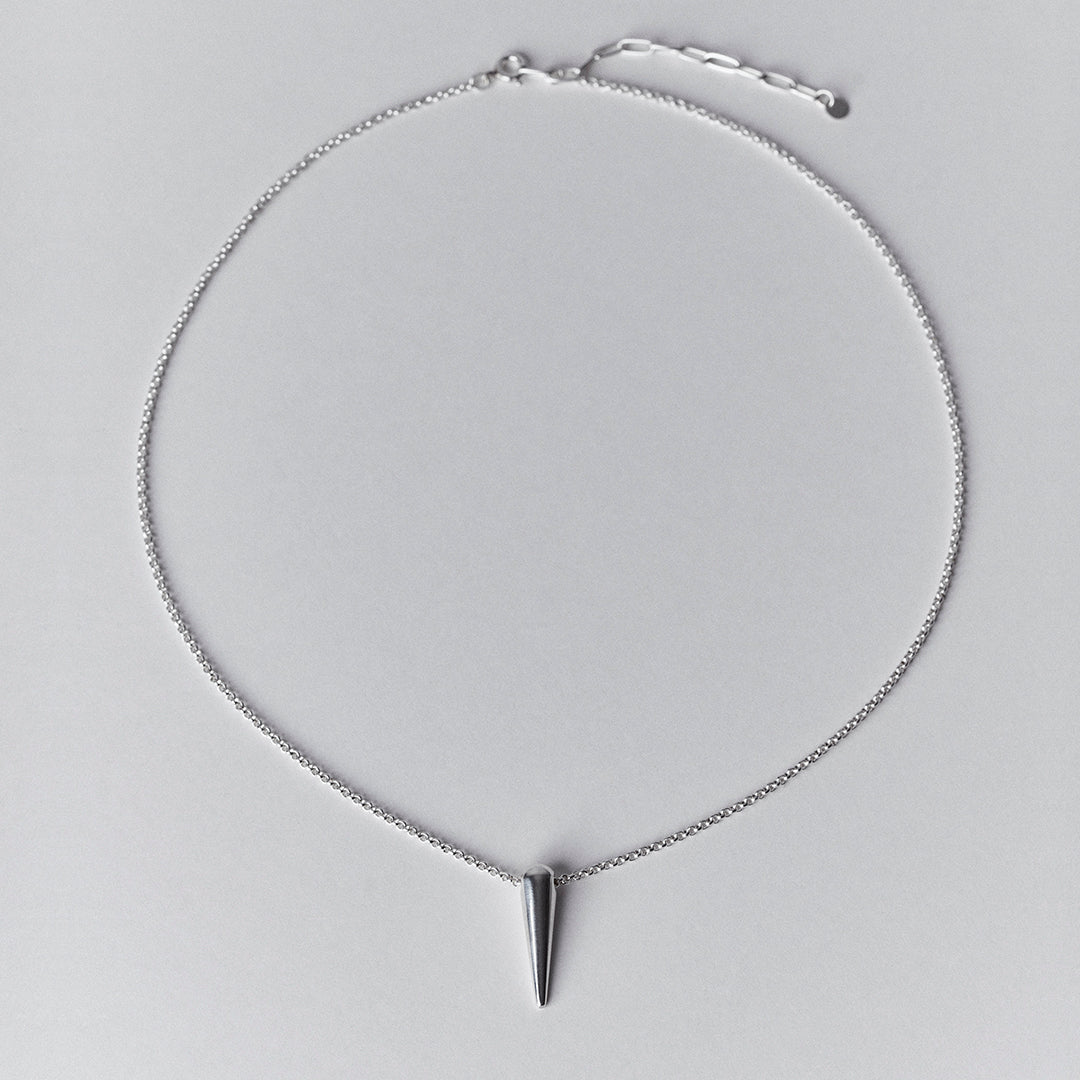 A silver spike shaped pendant necklace.