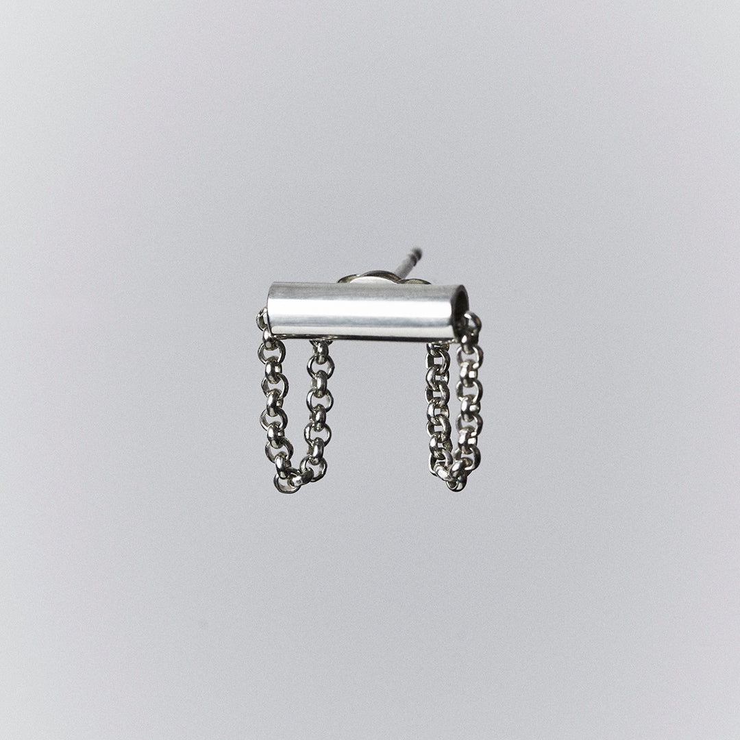 A silver earring with a chain running through a tube, creating a loop.