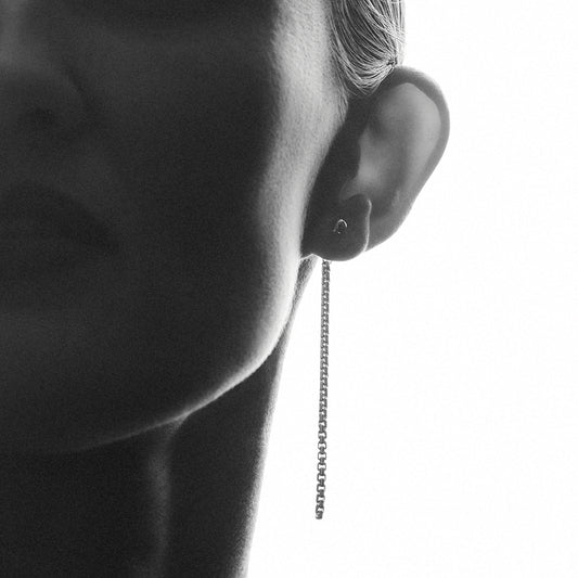 Woman wearing a long dangling, silver  earring